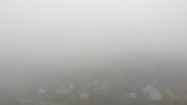 Kasaba aşılmaz yoğun bir sis içinde. Yoldaki kaza riskini artıran koşullar. Hava koşulları ve doğal elementler teması. Hava aracı 4K sinematik görüntüler