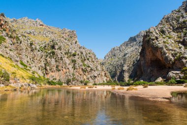 Dağ nehri yüksek uçurumlar arasında uzanır. Vahşi doğanın resimli manzarası. Yaz zamanı seyahat ve egzotik yerlere gitme zamanıdır..