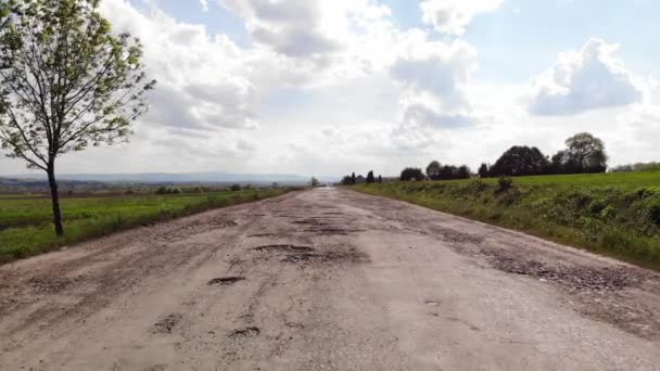 被毁的道路 沥青路面上有许多坑和坑洞 没有路标 路旁被损坏 — 图库视频影像