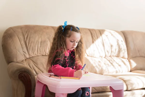 6歳の白人女の子が想像力から絵を描いています 家庭で才能のある子供を育てる 趣味のテーマ ストック写真