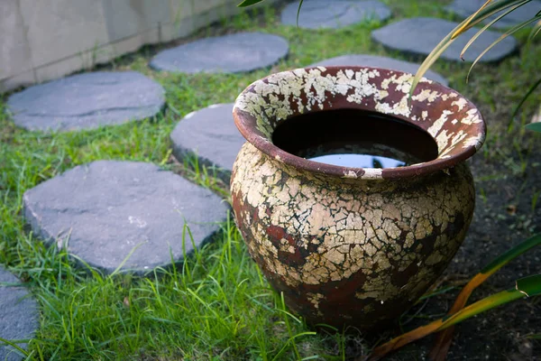 Gammal lera vas med vatten i trädgården på innergården — Stockfoto