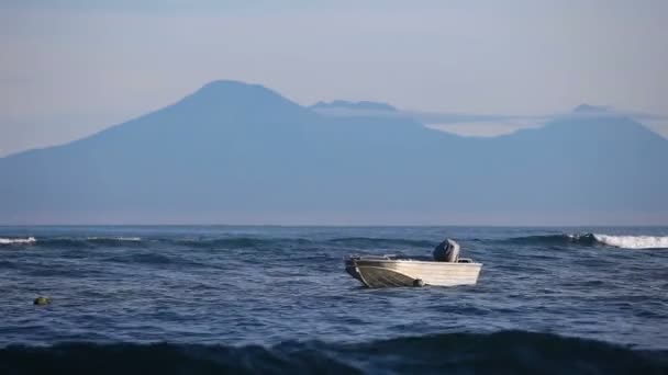 背景の山と海の桟橋にある小さなボート — ストック動画