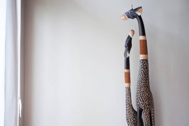 Beyaz bir duvar önünde ağaçtan Scrimshaw zürafa