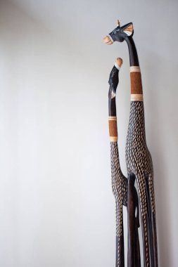 Beyaz bir duvar önünde ağaçtan Scrimshaw zürafa