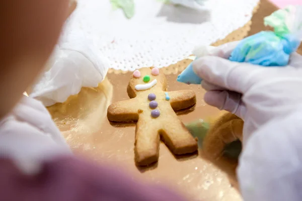 A folyamat, hogy Sandman a cookie-kat, manuálisan alkalmazza a máz, a gyermek kezét — Stock Fotó