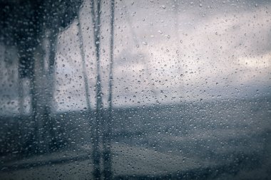 Yelkenli tekne ile denizde yağmur damlaları ile cam