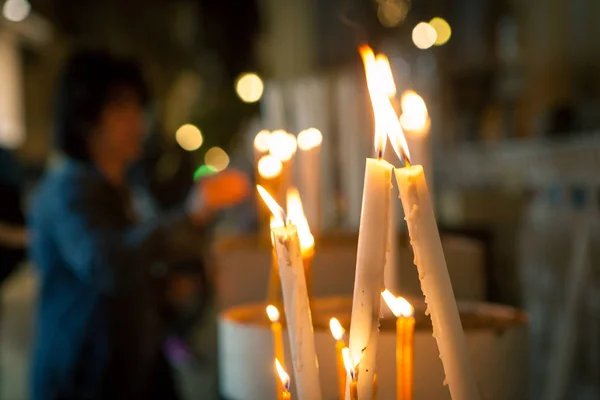Церковные свечи на фоне женщин — стоковое фото