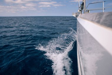 Denizde bir yelkenli tekne gemiye gelen dalgalar