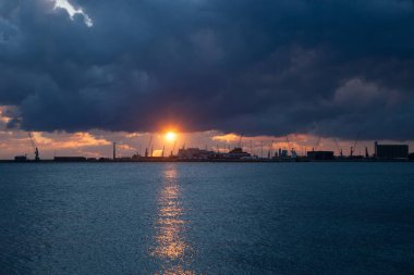 Sunrise ticari liman arka planda bulutlar tehdit ile denizin üzerinden