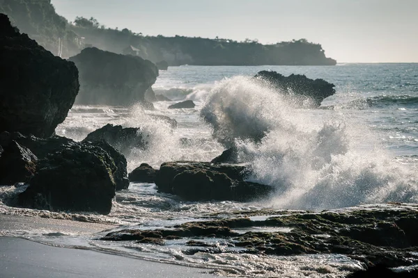 Ondas oceânicas colidindo com as rochas ao pôr do sol — Fotografia de Stock