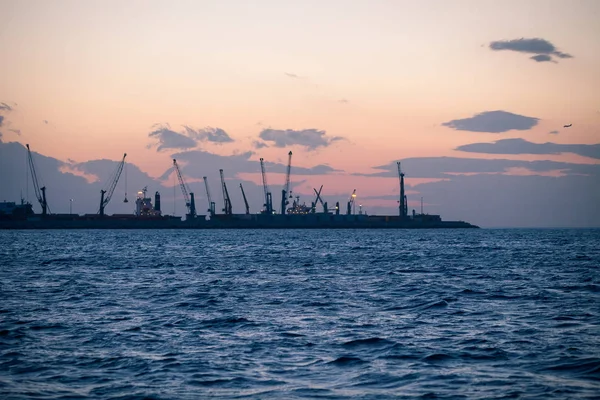 Námořní nákladní přístav s jeřáby při západu slunce — Stock fotografie