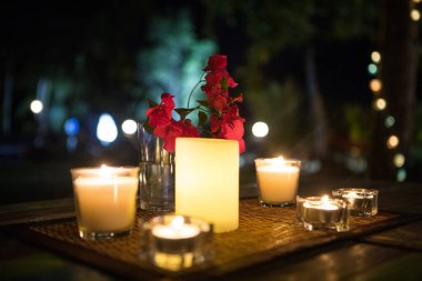 Romantik mumlar ve kırmızı çiçek kompozisyonu.