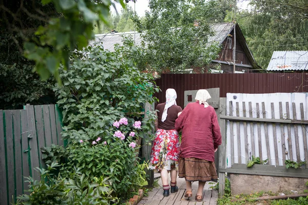 Two elderly women walk through the village yard — Stock Photo, Image