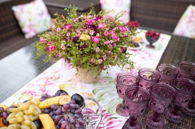 Masada böğürtlen ve çiçeklerle dolu güzel renkli mor bardaklar.