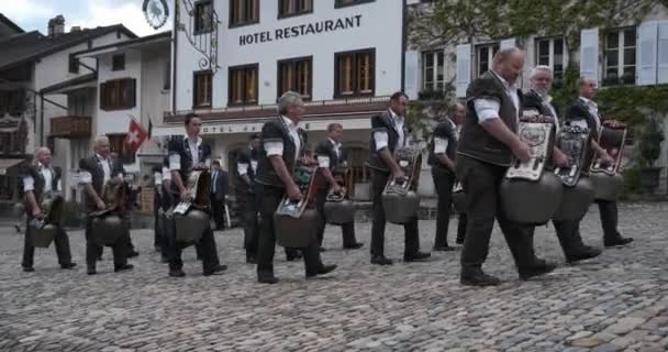 Gruyere, Szwajcaria - 2 maja 2019: lokalni muzycy w tradycyjnej odzieży wykonują muzykę do wielkich dzwonów krów na rynku miejskim — Wideo stockowe
