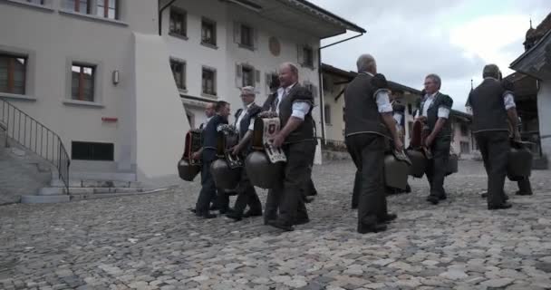 瑞士格鲁耶（Gruyere）- 2019年5月2日：当地传统音乐人在城市广场上为牛的大钟演奏音乐 — 图库视频影像