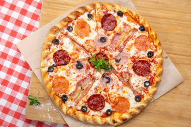 Pizza with different sausages close-up with different ingredients decorated with Basil