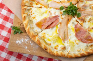 Pizza with different sausages close-up with different ingredients decorated with Basil