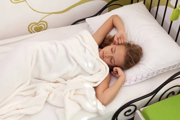 Young girl sleeping in her bed - with the morning light peeking — Stock Photo, Image