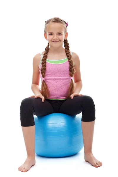 Happy young sporty girl sitting on large gymnastic rubber ball — Stock Photo, Image