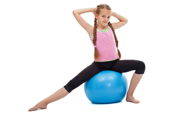 Büyük lastik topu egzersiz üzerinde oturan küçük kız — Stok fotoğraf