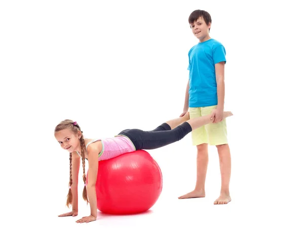 Chica joven haciendo ejercicio con una gran pelota de goma gimnástica — Foto de Stock