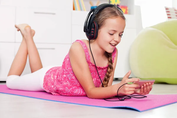 Giovane ragazza che utilizza il suo telefono ascoltando musica — Foto Stock