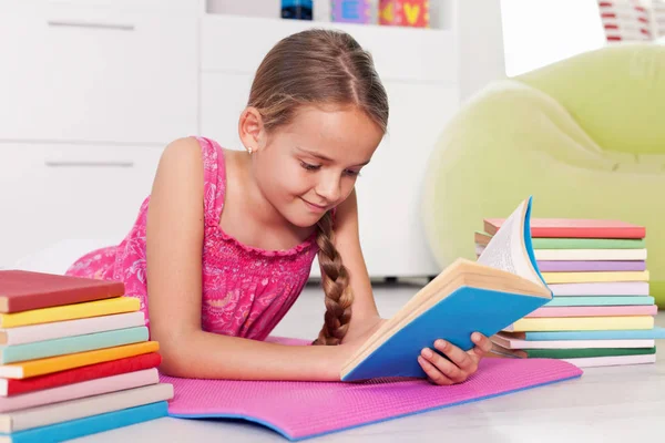Молода дівчина читає книгу вдома — стокове фото