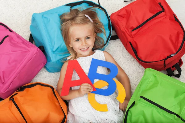 Bambina ansiosa di andare a scuola - sdraiata sul pavimento tra c — Foto Stock