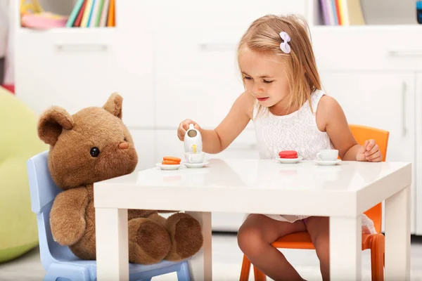 Menina brincando com seu urso de brinquedo - tendo uma festa de chá — Fotografia de Stock