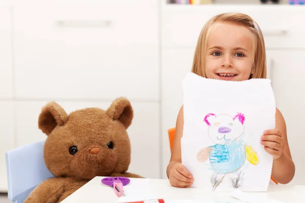 Menina apresenta seu desenho - um retrato de seu urso de brinquedo — Fotografia de Stock