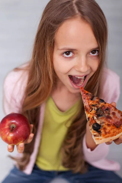Giving in to temptation - young girl choosing the slice of pizza — Stock Photo, Image