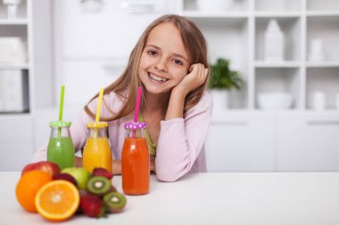 Çeşitli taze meyve suları olan mutlu genç kız.