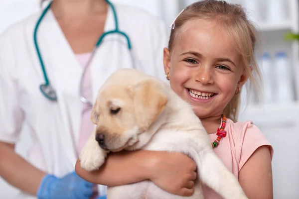 Šťastná holčička se svým štěňátkem psa na veterinární lékař — Stock fotografie