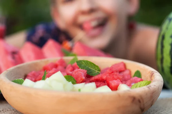 Happy girl enjoy healthy summer snack - a plate with pieces of c — Stock Photo, Image