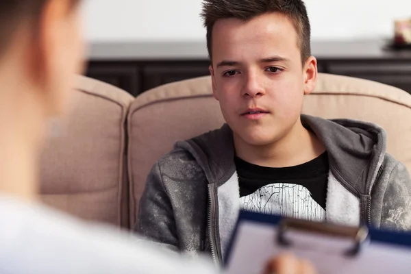 Young teenager boy at counseling - talking to the therapy profes — Stock Photo, Image