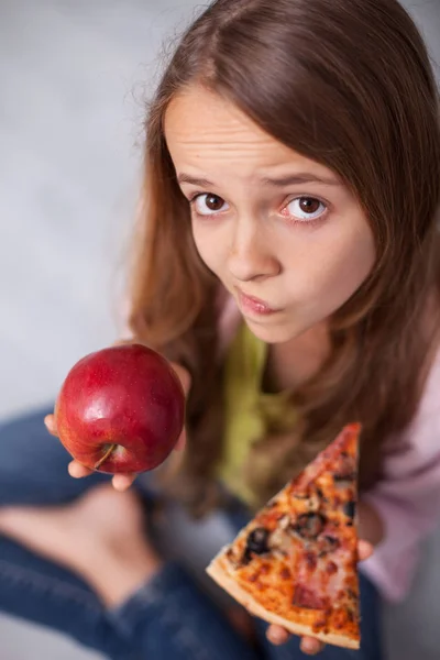 Zaskoczony młoda dziewczyna niezdecydowany wheter wybrać apetyczny piz — Zdjęcie stockowe