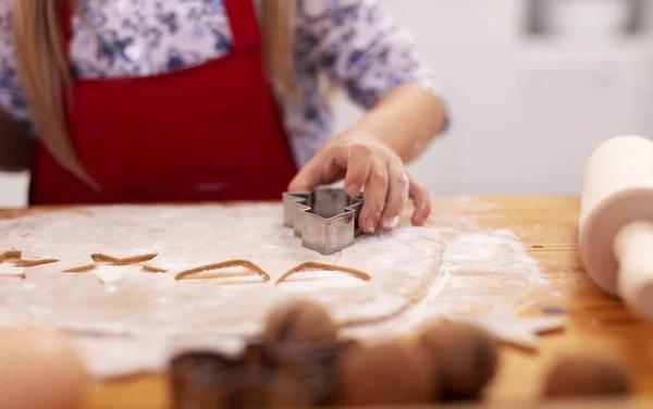 Kislány kézzel vág mézeskalács sütit tésztából — Stock Fotó