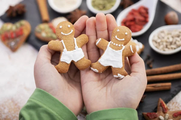 Young hands holding couple of gingerbread cookie people  - chris — Stock Photo, Image