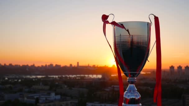 Copa líder ganador con cintas rojas y puesta de sol de oro — Vídeos de Stock