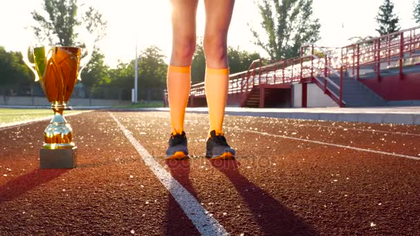Desporto menina pernas em uma corrida corrida com ouro vencedor copo — Vídeo de Stock