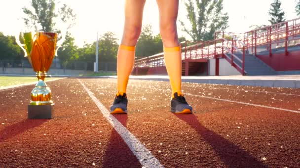 Sportsman pernas na corrida de corrida no estádio com copo de ouro vitória — Vídeo de Stock