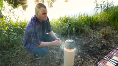 Adam bir su ısıtıcısı bir yangın açık kaynar