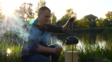 Adam bir çay ateşe yapar.