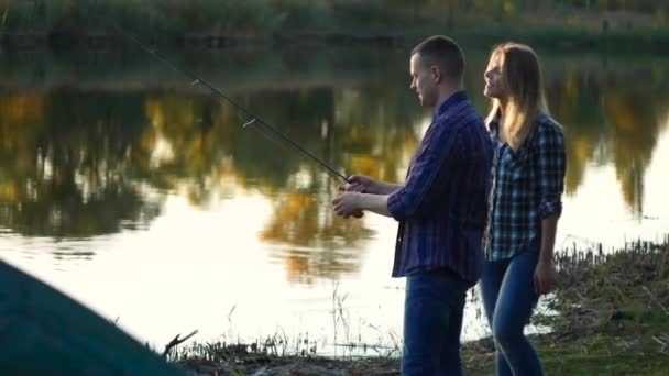 Šťastný mladý pár u jezera štika loví — Stock video