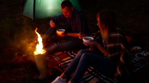 Cena nocturna en el campamento de turistas cerca de la hoguera — Vídeos de Stock