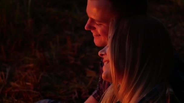 Young lovers smiling an night fire light — Stock Video