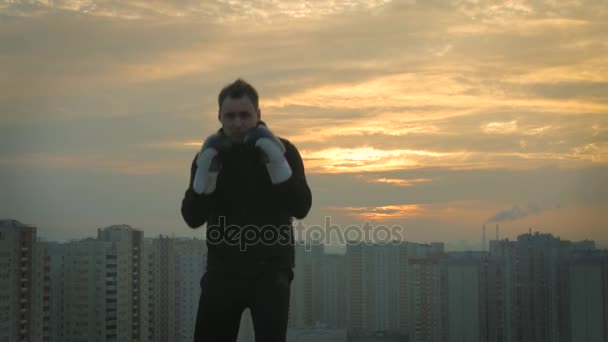 Hombre boxeador bien entrenado en el fondo del atardecer — Vídeo de stock