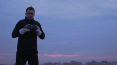 Gökyüzü arka plan üzerinde güçlü boksör yüzük maça davet ediyor.