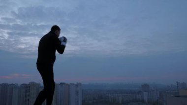 Street fighter büyük şehir geçmişi olan çatıdaki eğitim boks eldivenli